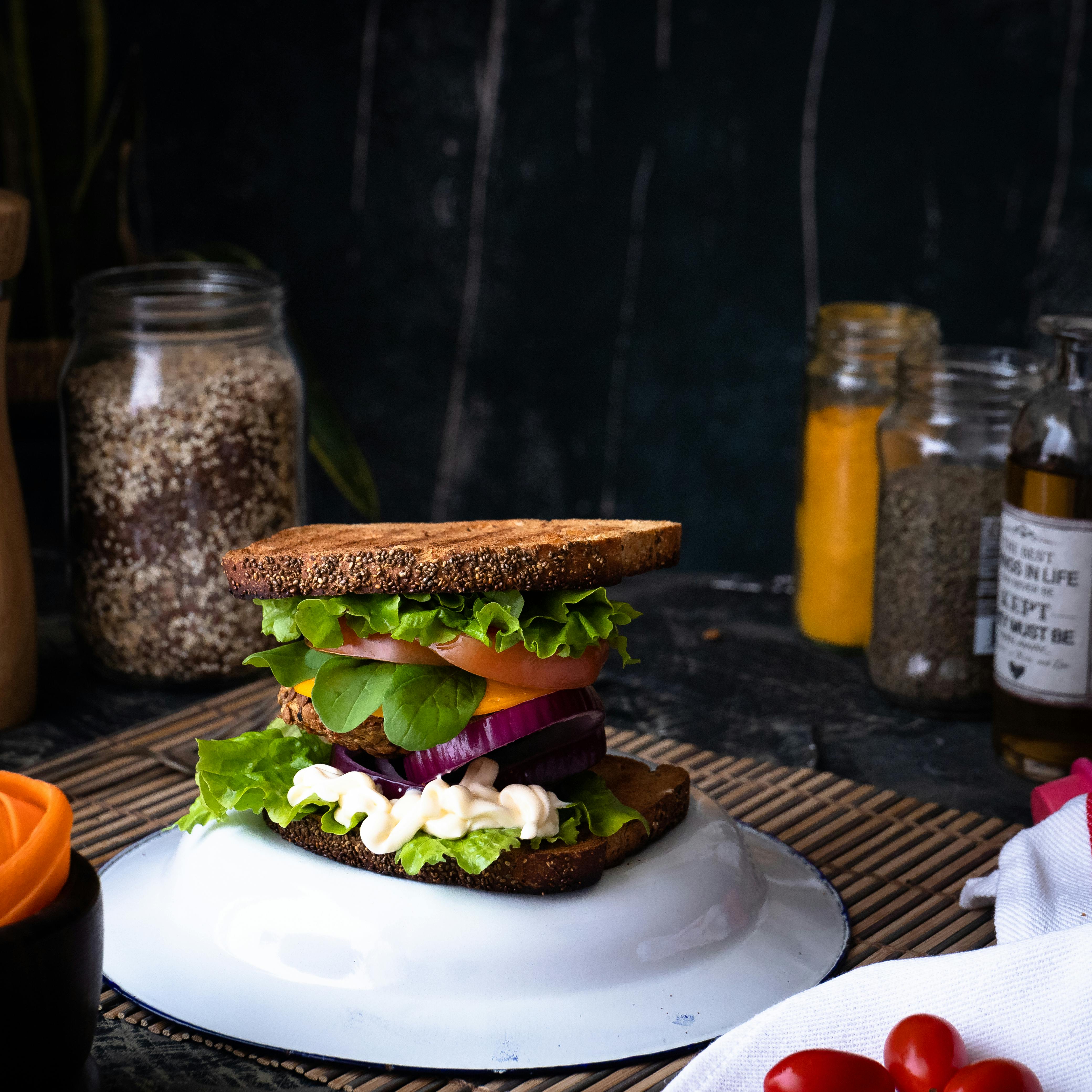 Delicious homemade vegan sandwich with fresh vegetables on a rustic table setting.